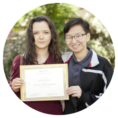 two female students holding scholarship certificate